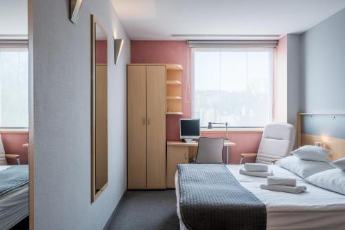 a bedroom with a bed and a desk with a computer at Weiser Hotel in Wrocław