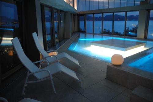 a swimming pool with two chairs and a table at PortBlue Club Pollentia Resort & Spa in Alcudia