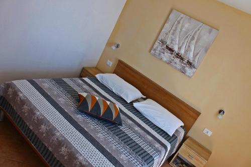 a bedroom with a bed with a picture on the wall at Apartment Ivana in Baška
