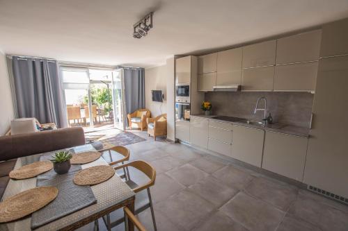 a kitchen and living room with a table and chairs at Blue Beach Panorama in Révfülöp