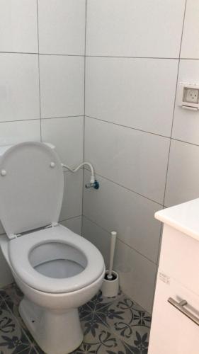 a bathroom with a white toilet with a pipe at Isramax apartment near the beach. in Bat Yam
