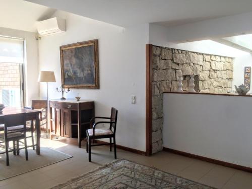 a living room with a table and a stone wall at Casa do O - Alojamento Local in Tábua