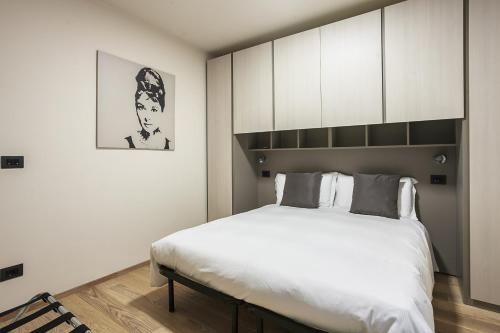 Schlafzimmer mit einem großen weißen Bett und Schränken in der Unterkunft Residence Rizzoli-Suites Apartments in Bologna