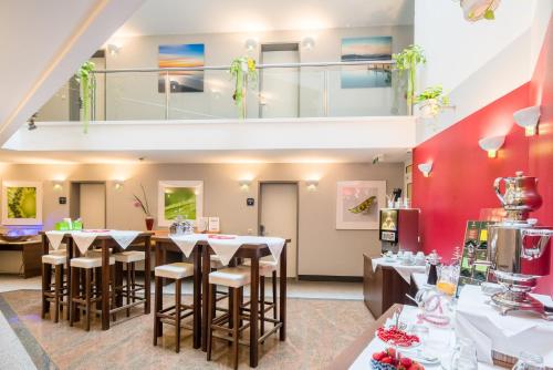 a restaurant with tables and chairs in a room at Best Western Plus Parkhotel Erding in Erding