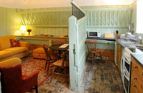 eine Küche mit einem Tisch, Stühlen und einem Sofa in der Unterkunft Brackenborough Hall Coach House - Stables in Louth