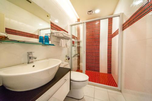 ein Bad mit einem Waschbecken, einem WC und einer Dusche in der Unterkunft Zi Jing Cheng B&B in Hualien