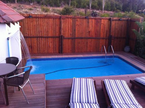a swimming pool on a deck with a wooden fence at Mountain View Eco Lodge Montagu in Montagu