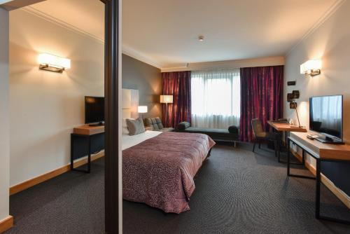 a hotel room with a bed and a desk at Martin's Château Du Lac in Genval