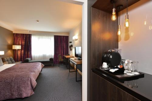 a hotel room with a bed and a desk at Martin's Château Du Lac in Genval