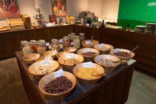 a table topped with bowls of different types of food at Hotel Weiher Green Lake in Falzes