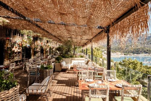 
a patio area with tables, chairs and umbrellas at Bikini Island & Mountain Port de Soller "Adults only" in Port de Soller
