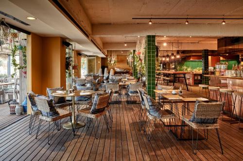 a restaurant with tables and chairs on a wooden floor at Bikini Island & Mountain Port de Soller "Adults only" in Port de Soller