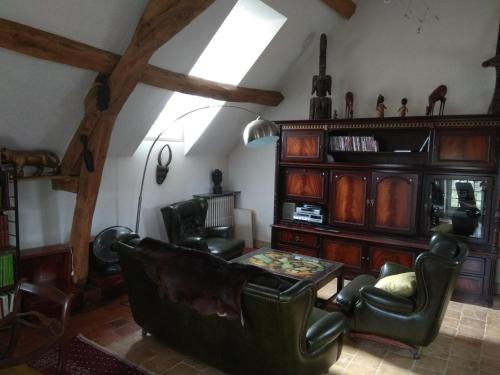 a living room with leather chairs and a table at Maison des Arts Francueil in Francueil