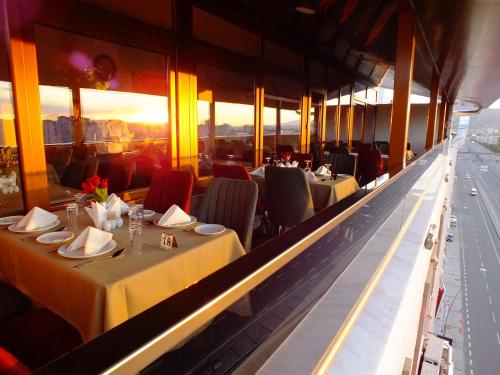 a restaurant with tables and chairs with the sun setting at Lifos Hotel in Kayseri