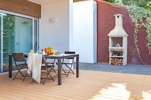 a table and chairs on a patio with a fireplace at Villa Chimera By LovelyStay in Caniço