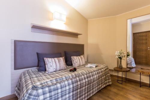 a bedroom with a large bed with a plaid blanket at Pierre & Vacances Andorra Bordes d’Envalira in Bordes d´Envalira 