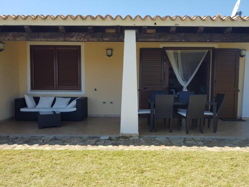 a patio with a couch and a table and chairs at Abba Urci in Tertenìa