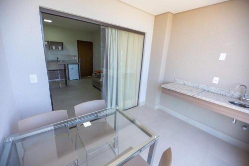 Habitación con mesa de cristal, sillas y espejo. en Alta Vista Thermas Resort, en Caldas Novas