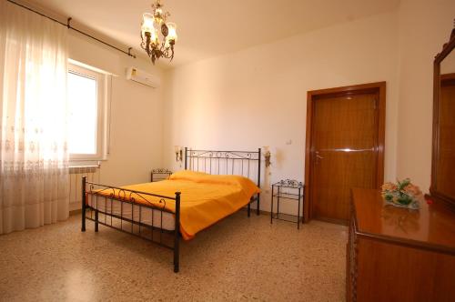 a bedroom with a bed with a yellow blanket at Appartamento al mare a Silvi Marina in Silvi Marina