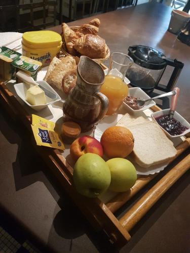 L'écurie في Saint-Germain-lès-Arlay: صينية طعام تحتوي على تفاح وخبز وعصير برتقال