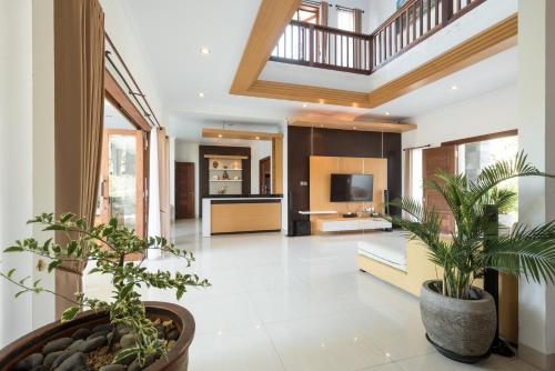 a living room with potted plants on the floor at Villa Melasti Wardana in Uluwatu