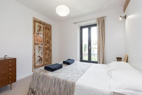 une chambre blanche avec un lit et une fenêtre dans l'établissement Migrainier côté cour, à Antibes