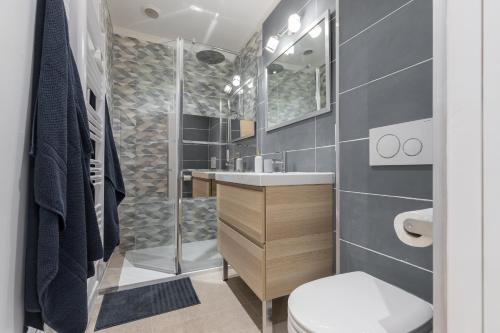 une salle de bain avec une douche, des toilettes et un lavabo dans l'établissement Migrainier côté cour, à Antibes