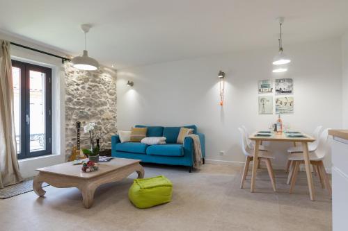 un salon avec un canapé bleu et une table dans l'établissement Migrainier côté cour, à Antibes