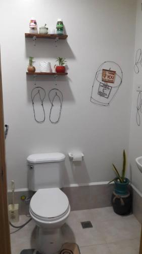 a bathroom with a toilet and shelves on the wall at The Treehouse B @ Trees Residences in Manila