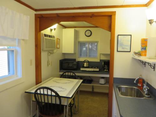 a small kitchen with a table and a sink at Elmwood Motor Court in Old Orchard Beach
