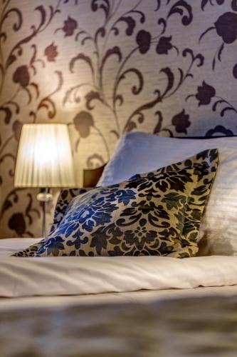 a bedroom with a bed with pillows and a lamp at Hotel-Restauracja Platan in Chrzanów