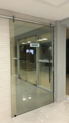 a sliding glass door with a television in a building at Hotel Oásis de Patos in Patos