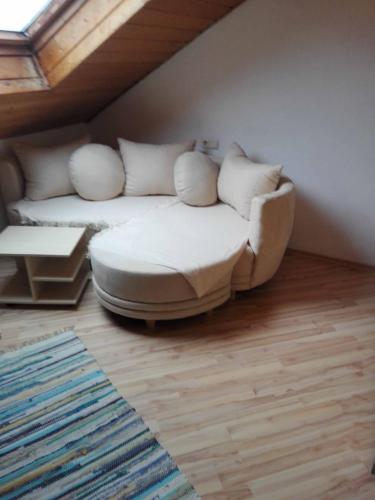 a living room with a white couch with pillows at Ferienwohnung Dichtl in Grafenau