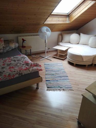 a bedroom with a bed and a couch and a window at Ferienwohnung Dichtl in Grafenau