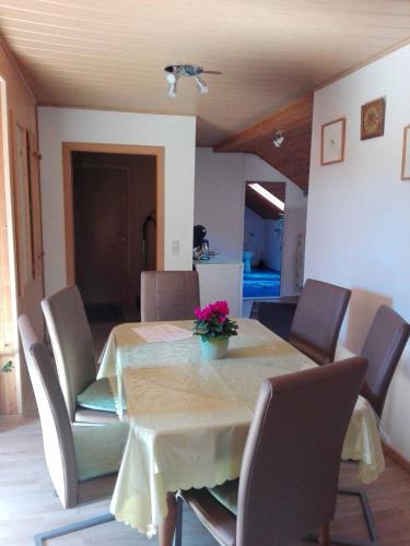 a dining room table with a vase of flowers on it at Ferienwohnung Dichtl in Grafenau