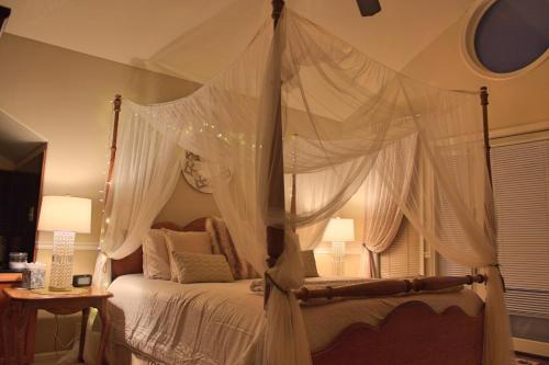a bedroom with a canopy bed with white drapes at Black Bear Manor in Ouray