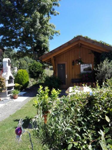 a garden with a small wooden building with a porch at Ferienwohnung Dichtl in Grafenau