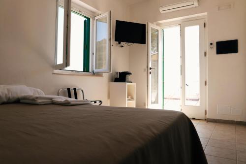 a bedroom with a bed and a window at Country House “ Il Mandorlo” in Acciaroli
