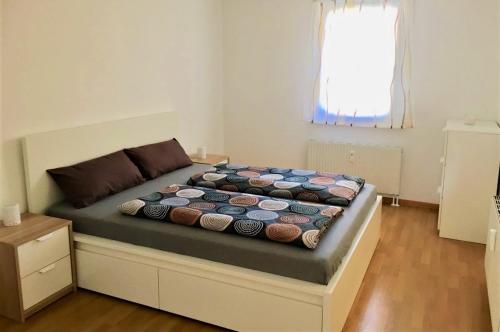 1 dormitorio con cama con edredón en BodenSEE Apartment Allensbach FEWO 2, en Allensbach