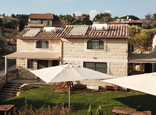 two white umbrellas in front of a house at Nof Sadot in Naẖam