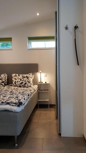 a bedroom with a bed and a nightstand and a window at PAX Apartments in Lund