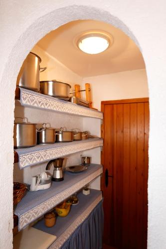 a kitchen with pots and pans on shelves at Casa Rural Mas de Sant Pau - Turistrat. in Albocácer