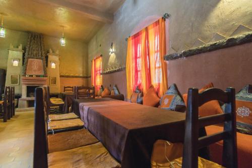 a bedroom with two beds in a room with a fireplace at Riad Dar Ouzine in Merzouga