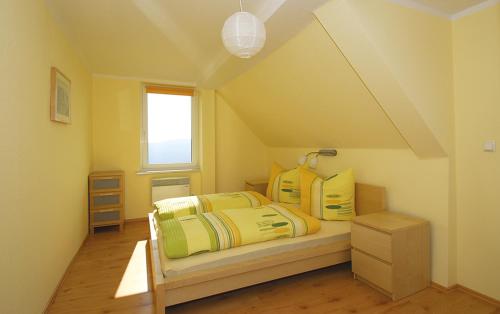 a bedroom with a bed with yellow and green sheets at Panorama-Apartments Weinberghaus in Mittelndorf
