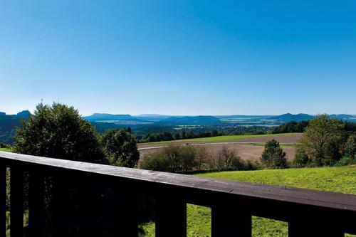 a wooden fence with a view of a field at Panorama-Apartments Weinberghaus in Mittelndorf