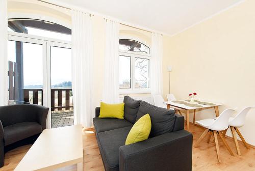 a living room with a couch and a table with yellow pillows at Panorama-Apartments Weinberghaus in Mittelndorf