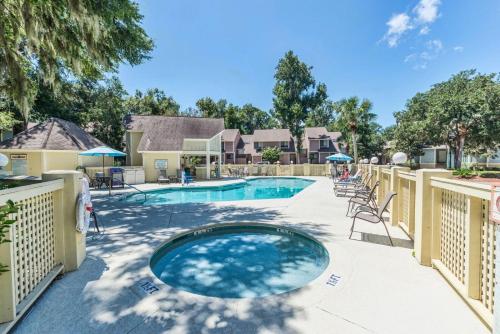 a swimming pool with a deck with chairs at Coral Reef Resort in Hilton Head Island