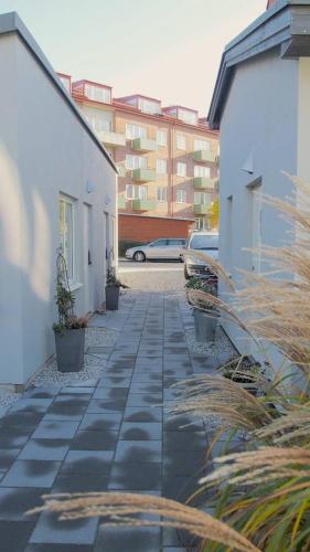 a stone walkway between two buildings with a car at PAX Apartments in Lund