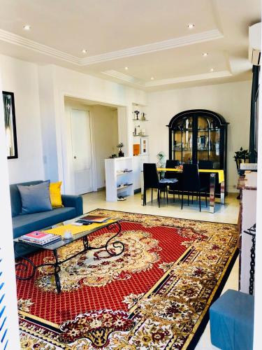 - un salon avec un canapé bleu et un tapis rouge dans l'établissement Apartment 3 Pieces, à Cannes