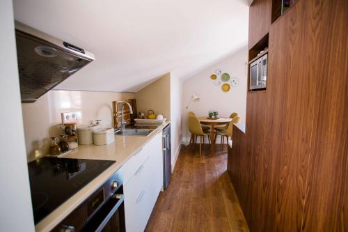 a small kitchen with a sink and a table at Casas do Jardim in Marco de Canavezes